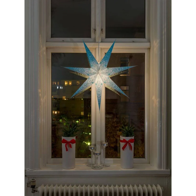 Blauer Papierstern perforiert und blau bestickt 7 Zacken ohne Leuchtmittel, beleuchtet im Fenster mit Pflanzen.