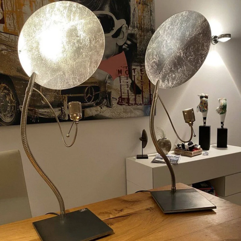 Catellani & Smith Luce d’Oro T LED Tischlampe in modernem Design mit indirektem Licht auf einem Holztisch.