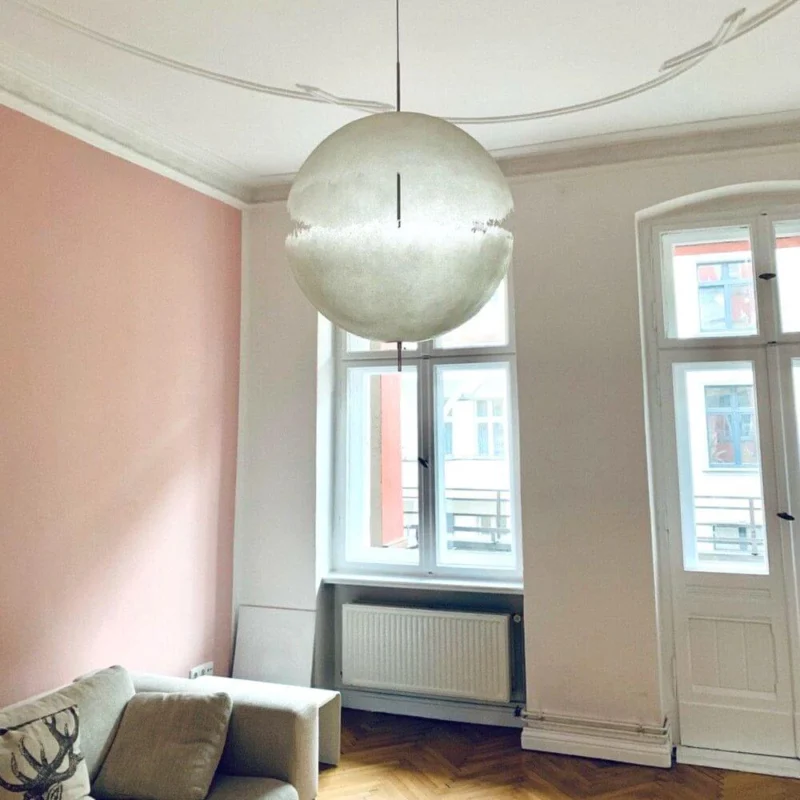 Catellani & Smith PostKrisi 65 LED Hängelampe Ø 40cm in modernem Wohnzimmer mit pinker Wand.