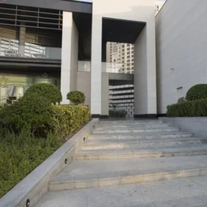 Moderne Fassade eines Gebäudes mit Treppe und Gartenanlagen, ideal für Architektur- und Design-Inspiration.