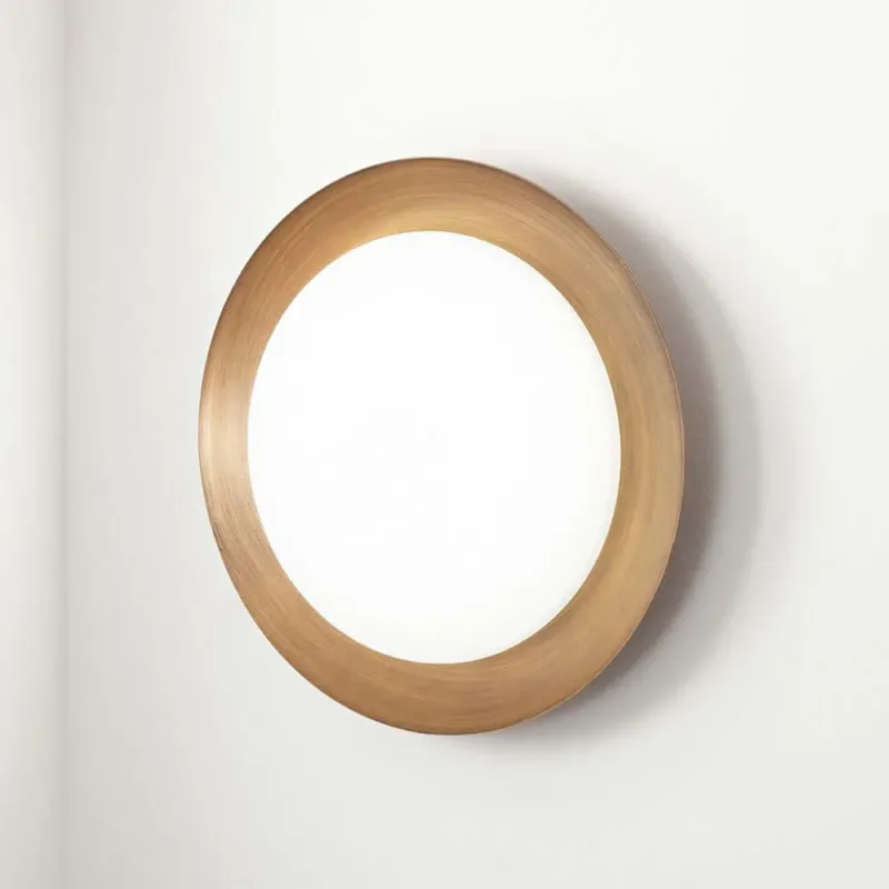 Crew 1 LED-Deckenleuchte Medium in runder Form mit goldenem Rahmen an der Wand.