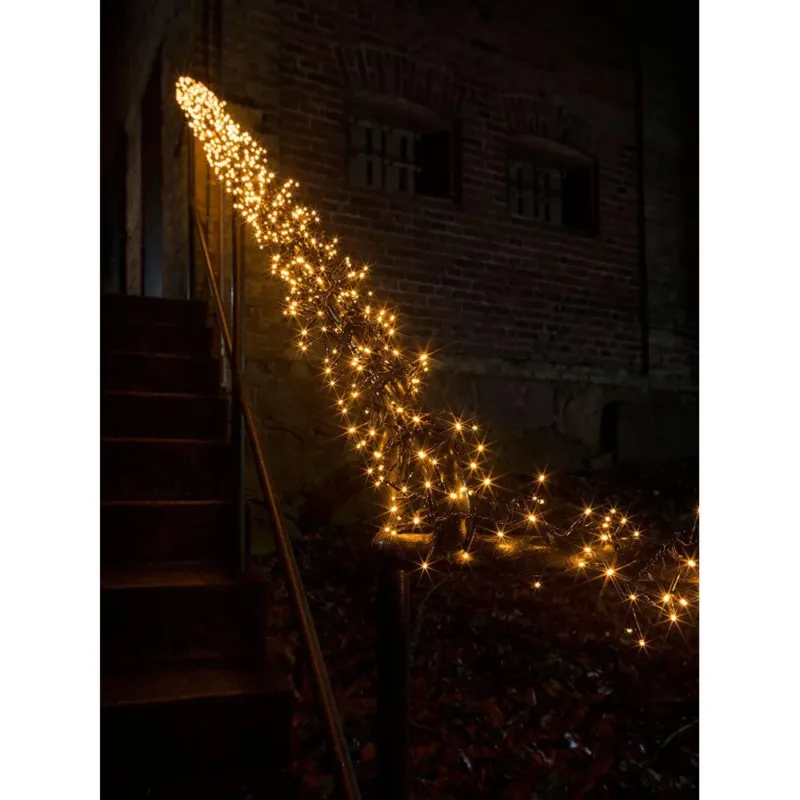 9m Micro LED Büschellichterkette Cluster mit 8 Funktionen 960 bernsteinfarbene Dioden IP44 an einem Treppengeländer im Dunkeln.