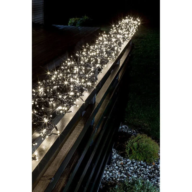 7,7m Micro LED Büschelllichterkette Cluster mit 8 Funktionen 768 Warmweiße Dioden IP44 auf einer Gartenbank bei Nacht.