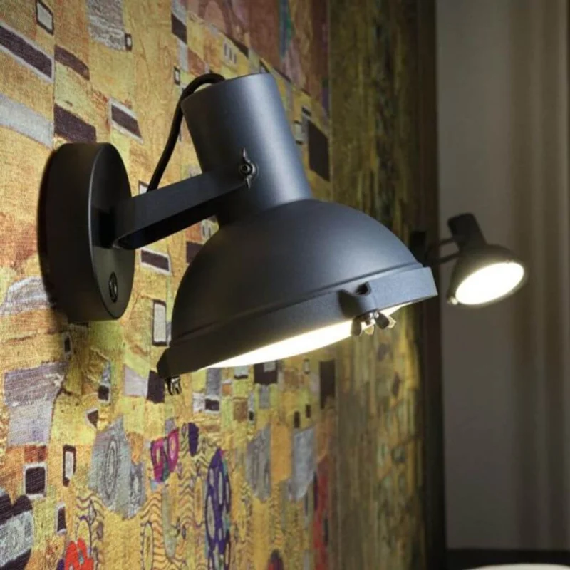 Nemo Projecteur 165 Wandleuchte drehbar an einer bunten Wand, verstellbar und aus Aluminium gefertigt.