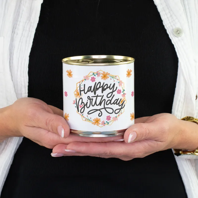 Dosenkuchen Brownie mit Happy Birthday Blumenmotiv in den Händen als Geschenk für Arbeitskolleginnen