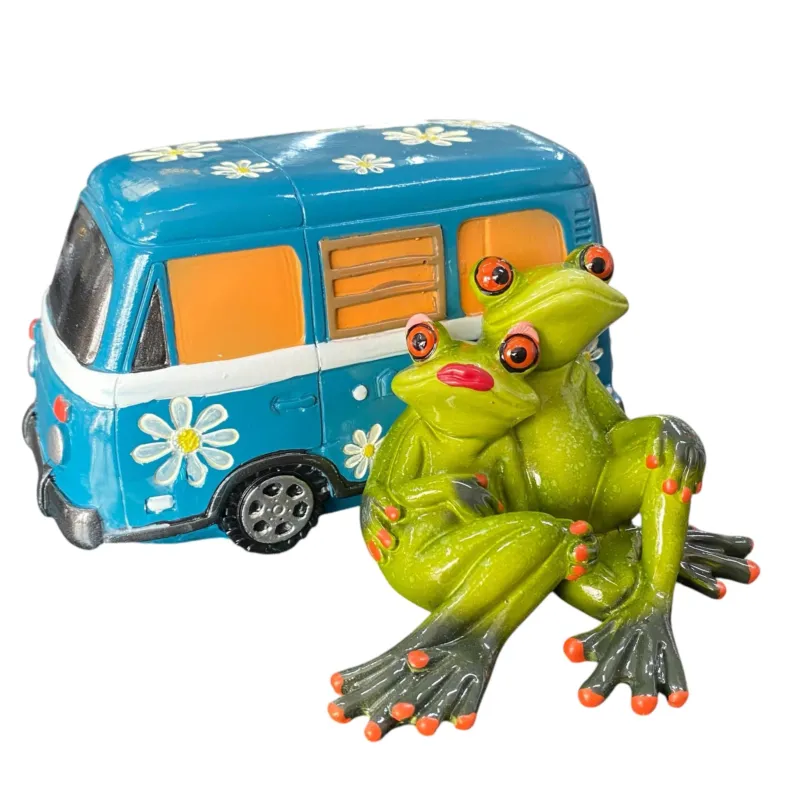 Zwei grüne Deko Frösche kuscheln vor einem blauen Hippie-Campingbus mit Blumen