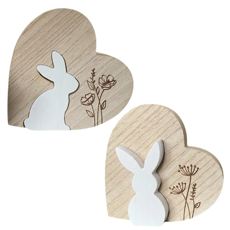 Zwei Holzherzen mit weißem Osterhasen, den man herausnehmen kann und Blumengravur. Bei einem Herz sitzt der Hase, bei dem anderen steht der Osterhase.