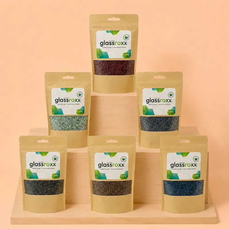 Sachets de granulats de verre recyclé GlassRoxx présentés sur un présentoir en bois