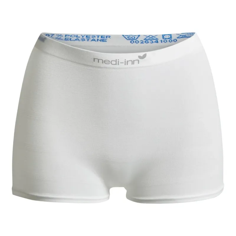 Weiße Fixierhose der Marke "medi-inn" in Größe M. Die Hose besteht aus einem elastischen Polyester-Elasthan-Gemisch und dient zur sicheren Fixierung von Inkontinenzmaterial. Das Produkt hat einen breiten, elastischen Bund mit Aufdruck der Materialzusammensetzung und Pflegehinweisen.