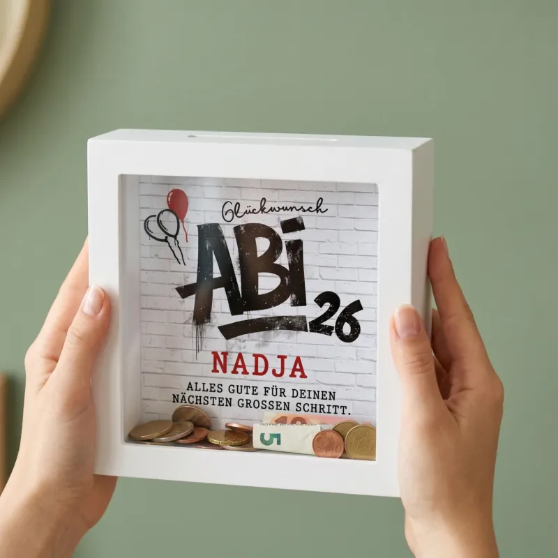 Personalisierte Spardose mit Abi 26 Motiv und Name Nadja, in beiden Händen gehalten