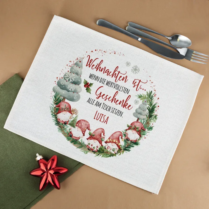 Platzdeckchen aus Jute mit Wichtelmotiv und personalisiertem Namen auf festlich gedecktem Tisch mit Besteck und Weihnachtsdeko.