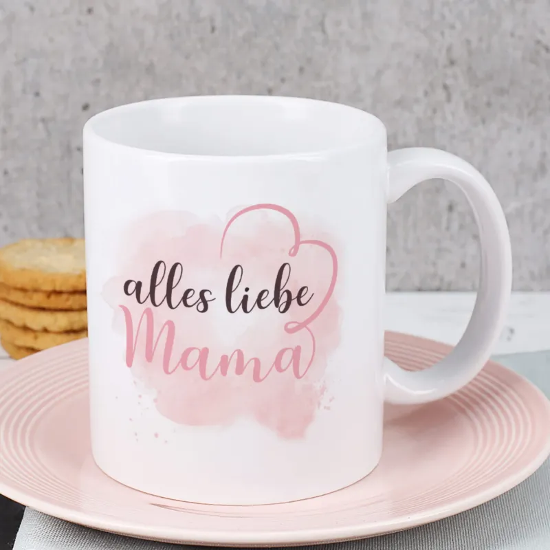 Nahaufnahme der Tassenvorderseite mit Spruch „Alles Liebe Mama“ und Herzlinien-Motiv auf rosa Aquarellhintergrund