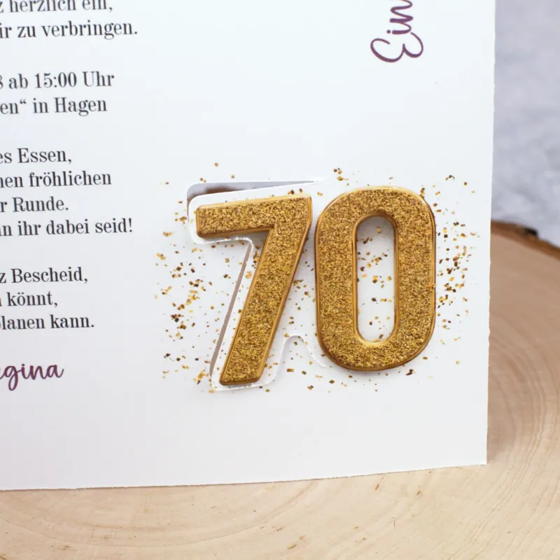 Detailaufnahme der goldenen Zahl 70 auf der Innenseite der Karte