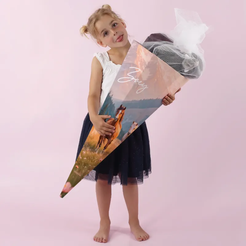 Mädchen mit personalisierter Schultüte mit Wildpferd-Motiv zur Einschulung