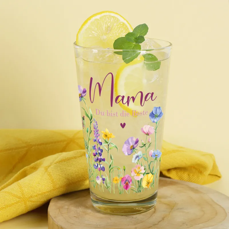Aufnahme des Trinkglases mit individuellem Wunschtext unter dem „Mama“-Schriftzug und floraler Verzierung.