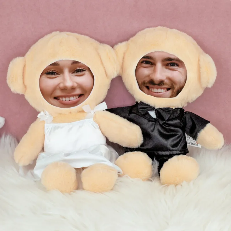 Teddy Brautpaar mit eigenen Fotogesichtern sitzend auf weißem Fell vor rosa Hintergrund