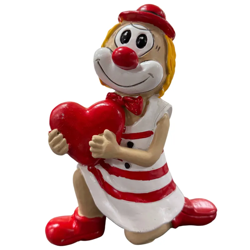Große Clown-Dekofigur mit roter Nase in rot-weißem Outfit, ca. 20 cm groß, kniend dargestellt und ein rotes Herz vor dem Körper haltend, vor weißem Hintergrund.