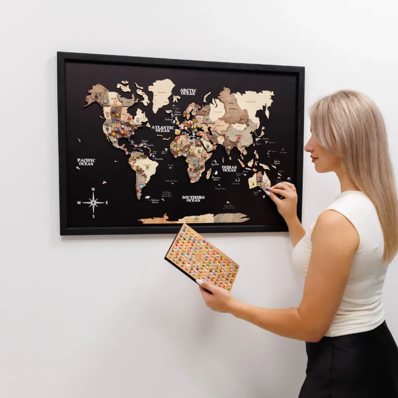 Woman pointing at a framed world map on a wall